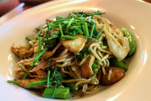 a bowl of Asian noodles with chicken and vegetables