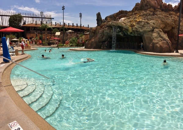 A group of people in swimming pool with sunny skies overhead