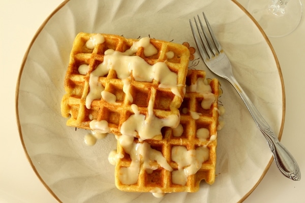 overhead view of a plate of sour cream orange waffles with a fork on the side