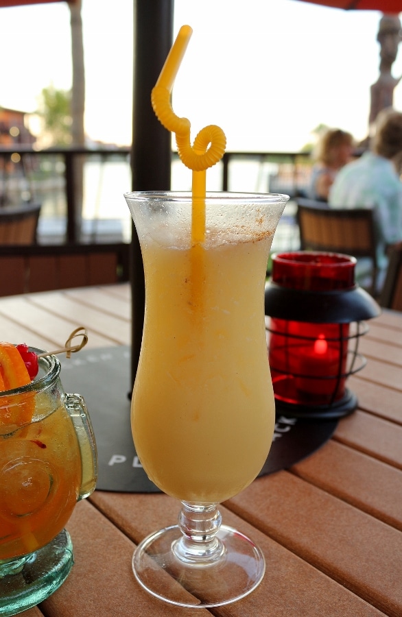 a closeup of a tropical drink in a tall hurricane glass