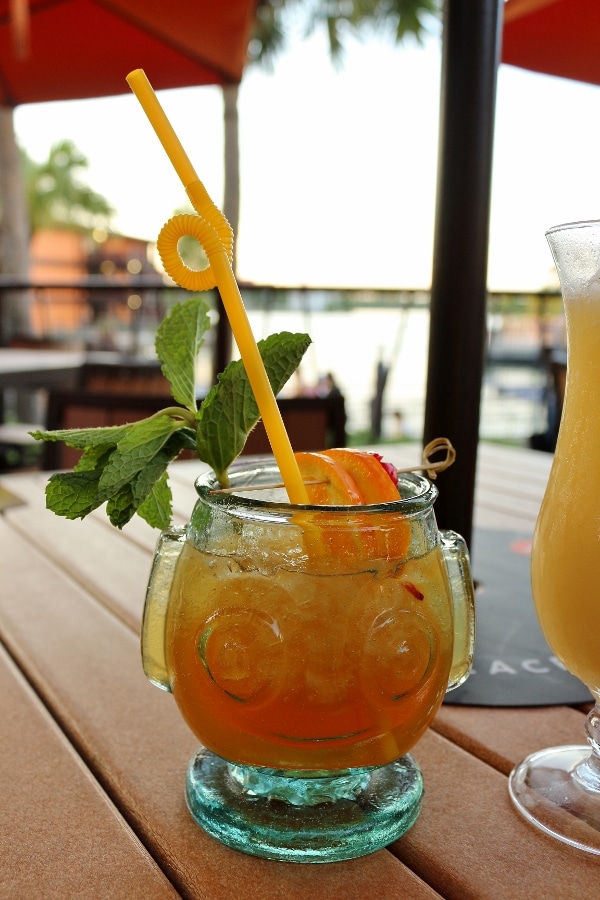 A close up of a tiki drink in a glass with a face