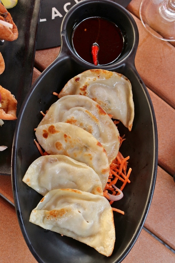 pan-fried dumplings served on a black plate