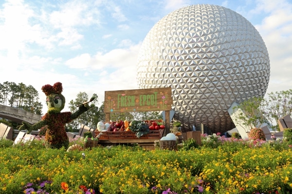 A close up of a flower garden in front of Spaceship Earth in Epcot