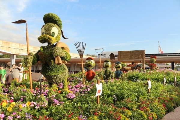 a topiary display of Donald Duck and his nephews gardening