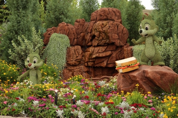 a topiary display of Chip and Dale eating a sandwich