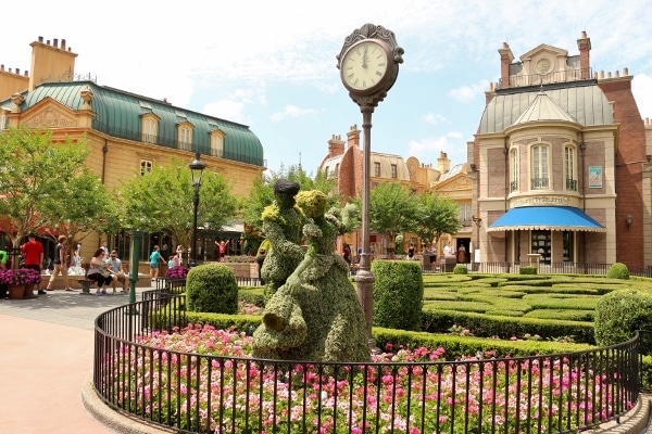 a Cinderella topiary in front of a clock in the France Pavilion in Epcot\'s World Showcase