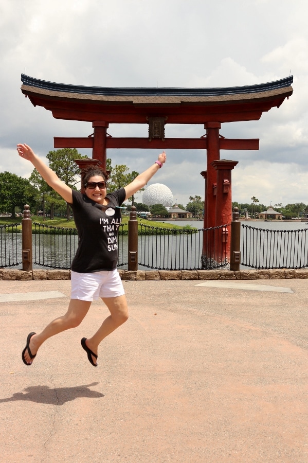 a woman jumping in front of an arch in Epcot\'s Japan Pavilion