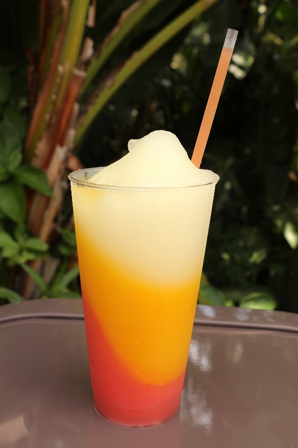 a tri-colored frozen margarita in a tall glass