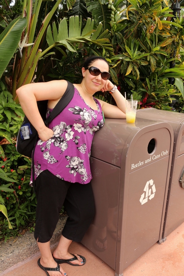 A woman leaning on a trash can