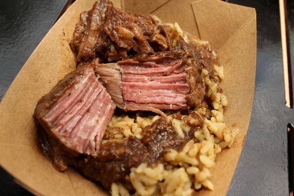 a closeup of a piece of braised beef with rice on a plate