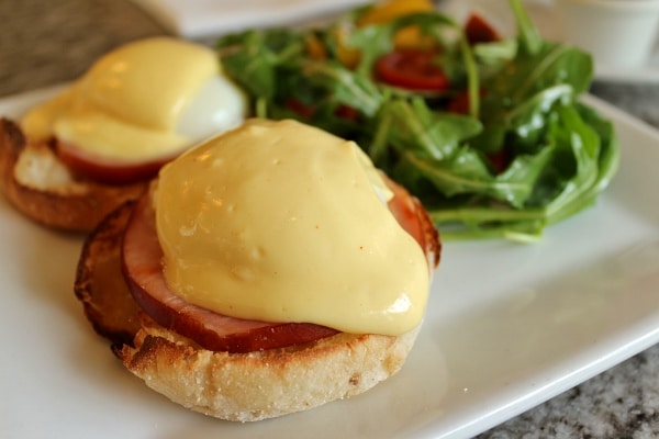 A plate of Eggs Benedict with salad