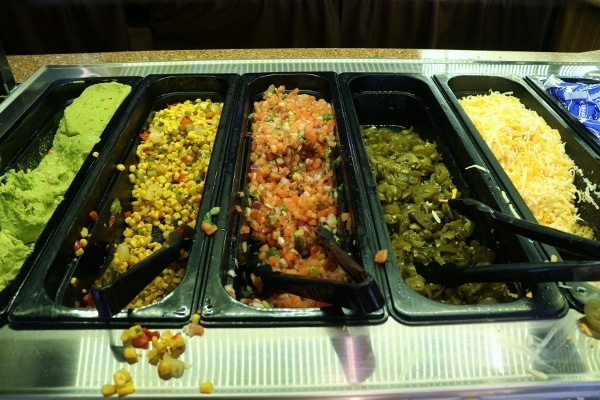 a buffet style area with toppings for Mexican food