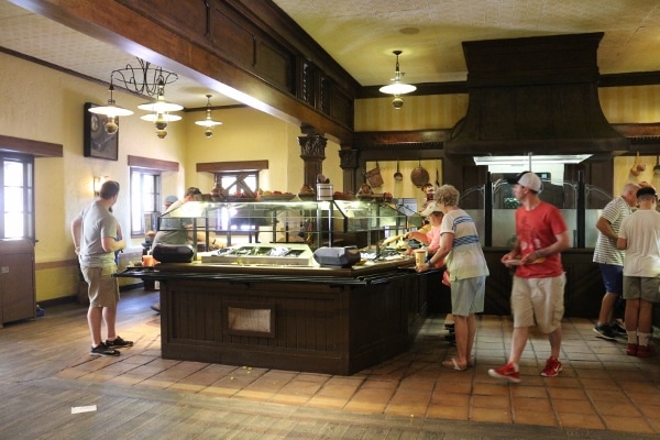 A group of people standing around a buffet area