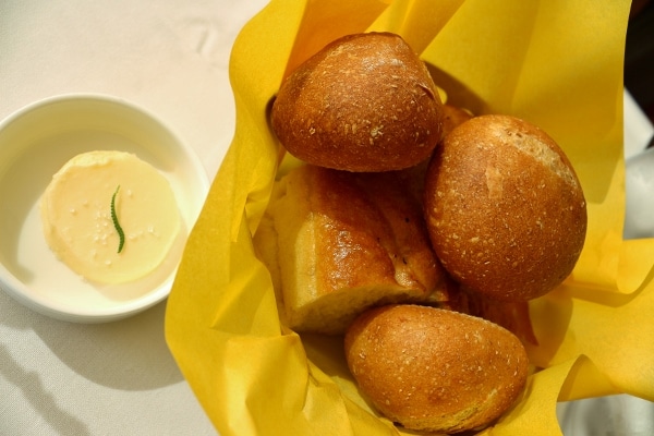 a bread basket, and a pat of butter in a small dish