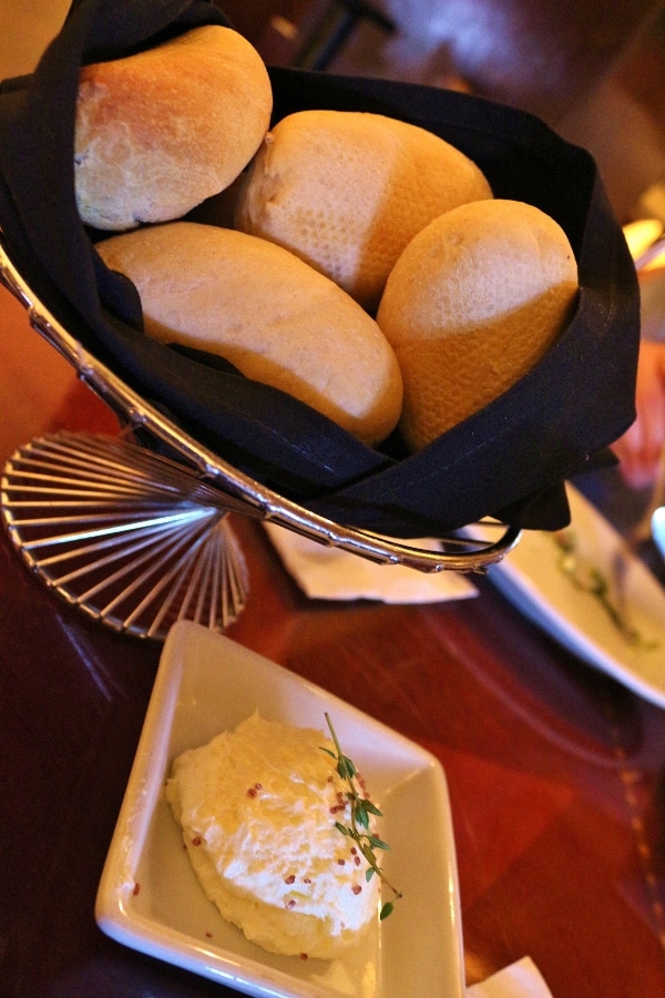 a bread basket and a dish of soft butter