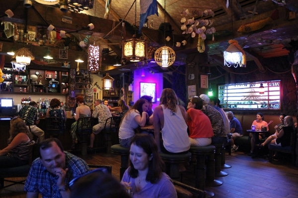 A group of people inside a dark tiki bar