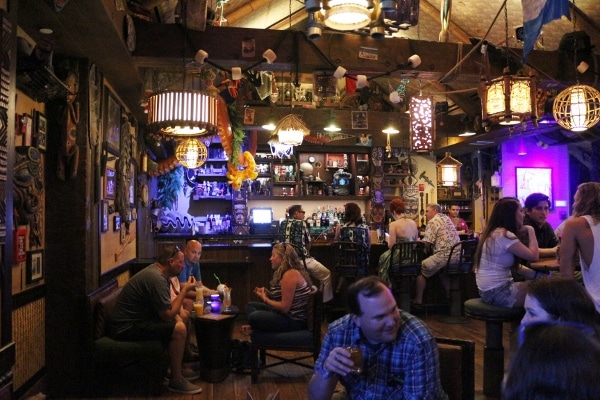 A group of people inside a dark tiki bar