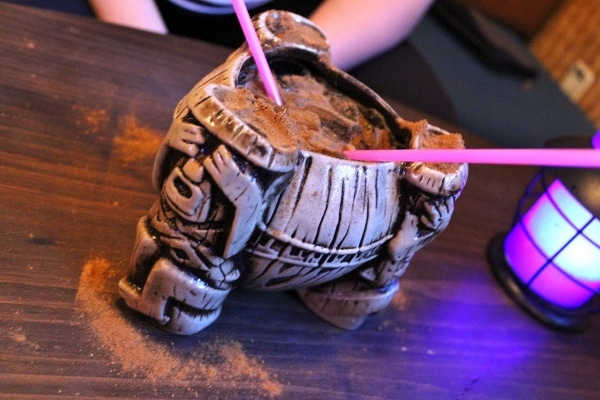 a large tiki drink with two straws