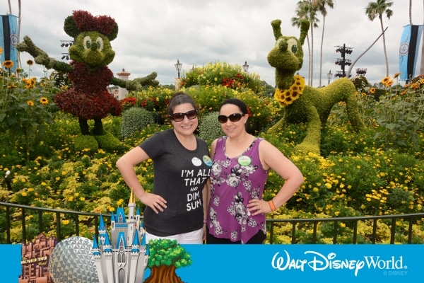 two women posing in front of Minnie Mouse and Pluto topiaries