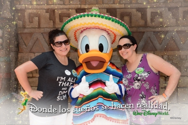 two women posting with Donald Duck dressed in Mexican clothing