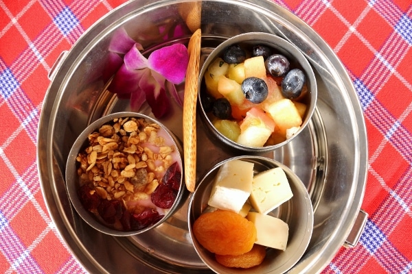 small metal cups filled with fruits, cheeses, and yogurts in a larger metal container