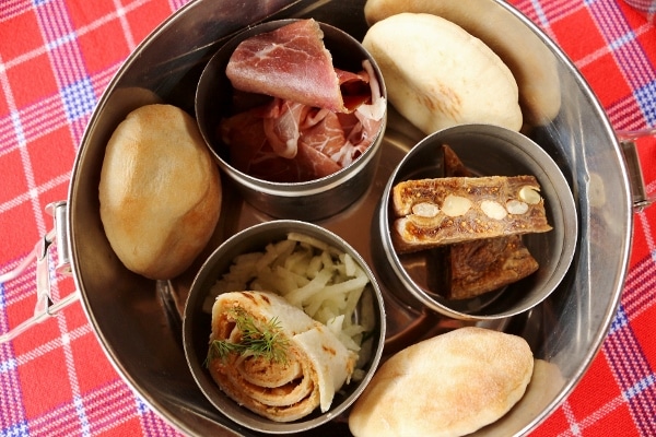 small metal cups filled with cured meat and a wrap in a larger metal container