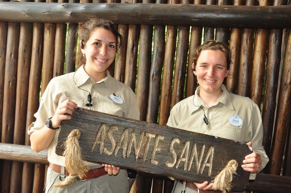 two people holding a sign that says Asante Sana
