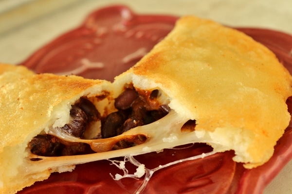 A close up of an empanada broken in half to show the filling