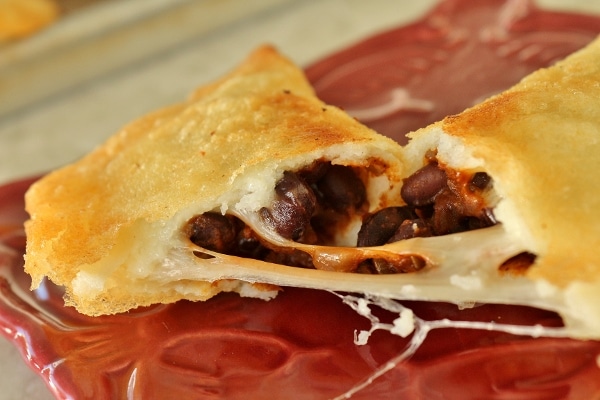 A close up of the black bean and cheese filling inside a fried empanada