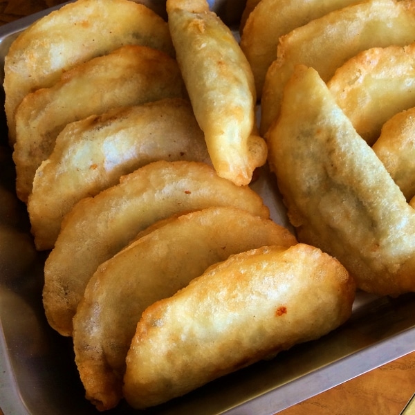 fried empanadas arranged in a metal pan