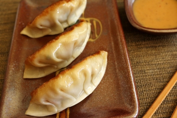 A plate of three pan-fried dumplings