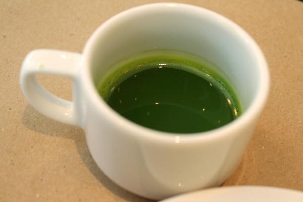 A close up of a small cup of matcha tea