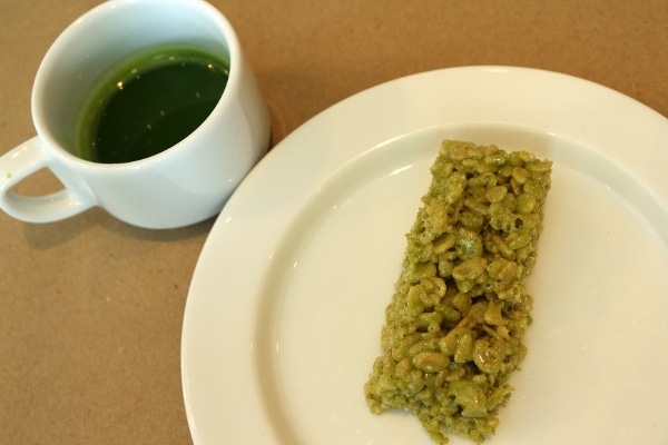 a cup of matcha tea and a matcha rice krispie treat on a plate