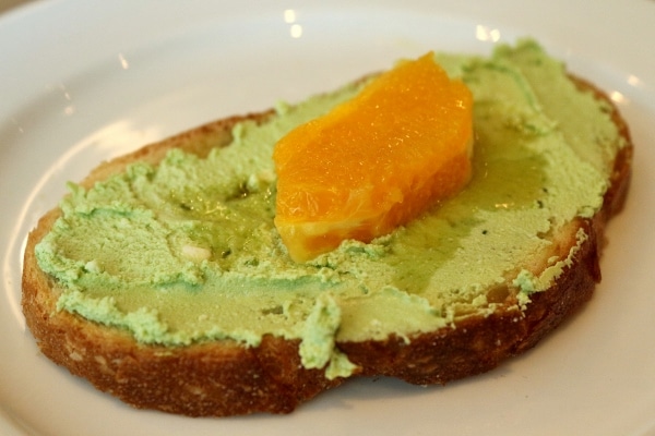 toasted bread with matcha goat cheese and an orange segment on top