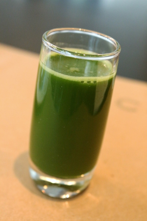 a green drink in a tall shot glass