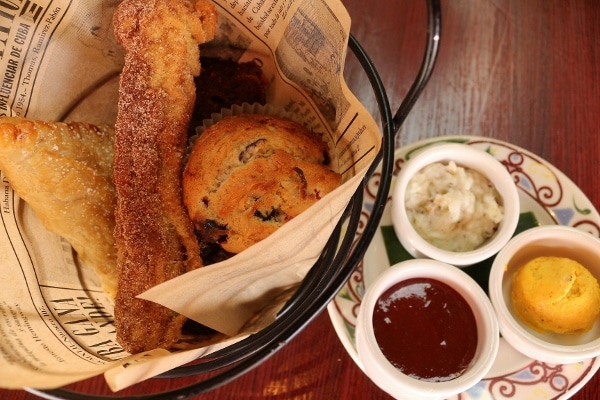 a small basket of pastries with various dipping sauces