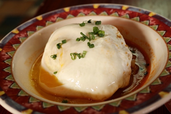 a colorful dish of food topped with a cooked egg