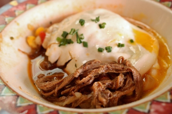 a closeup of a bowl of stewed beef topped with a cooked egg