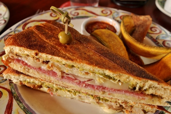 A Cuban sandwich cut in half on a plate