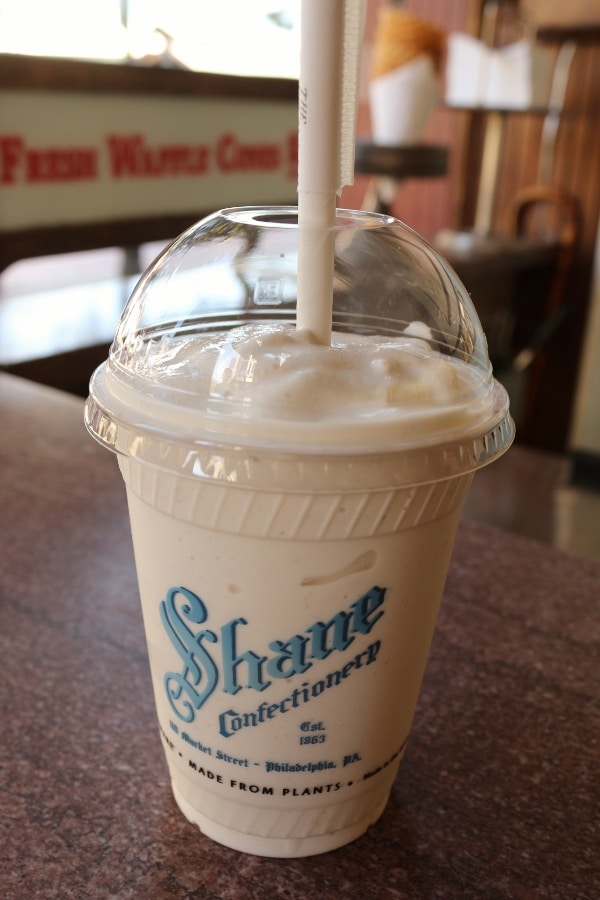 A close up of a milkshake in a plastic cup