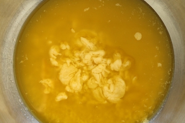 a broken sauce covered in oil in a mixing bowl