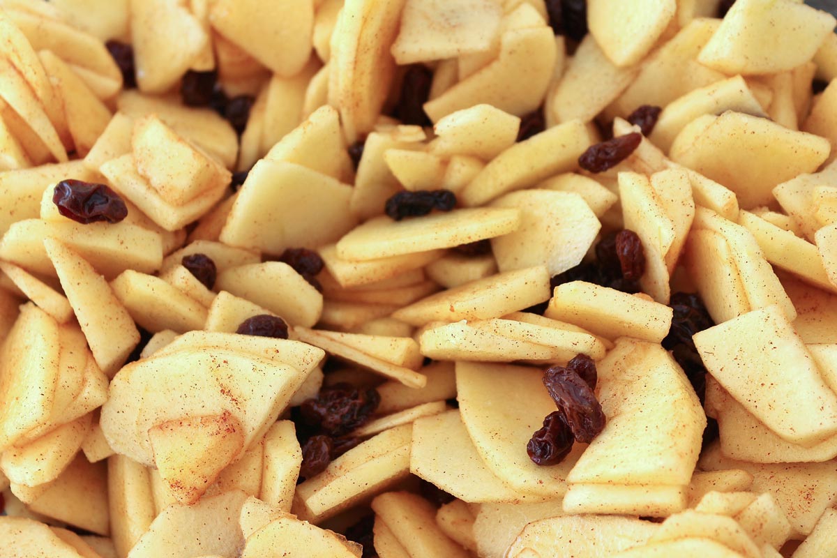 a closeup of sliced apples and raisins combined with spices.