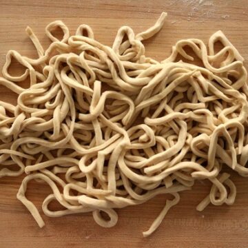 fresh udon noodles on a wooden board