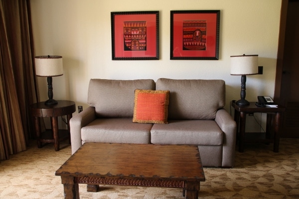 a small sofa with a coffee table in front and lamps on either side