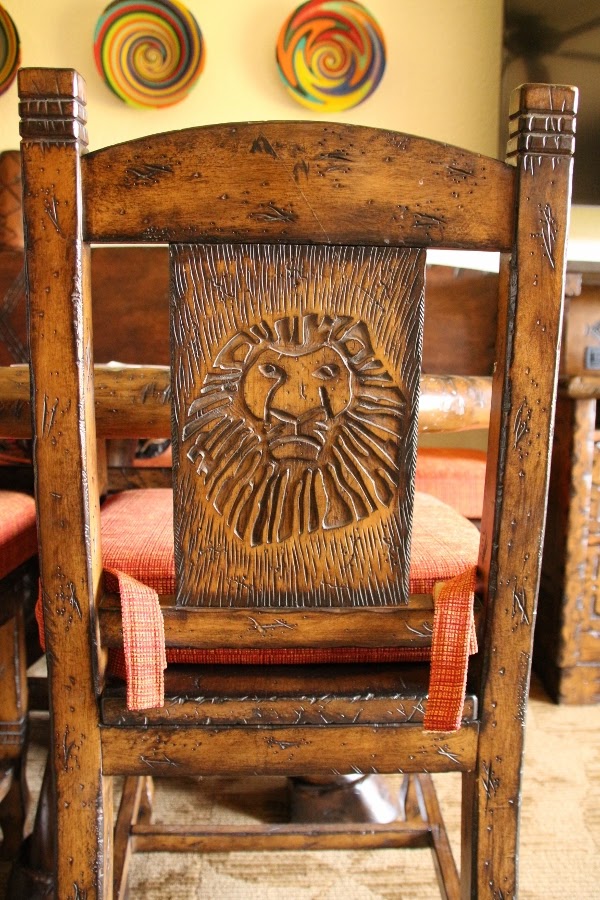 a Lion King carving on the back of a wooden chair
