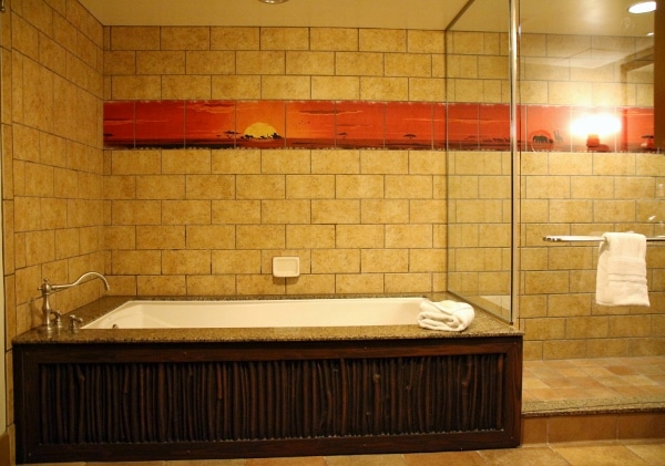 a bathtub next to a glass shower