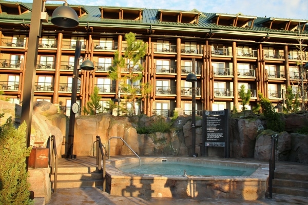 an outdoor jacuzzi with Disney\'s Wilderness Lodge in the background