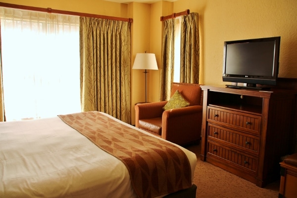 a hotel room with a large bed, dresser and television