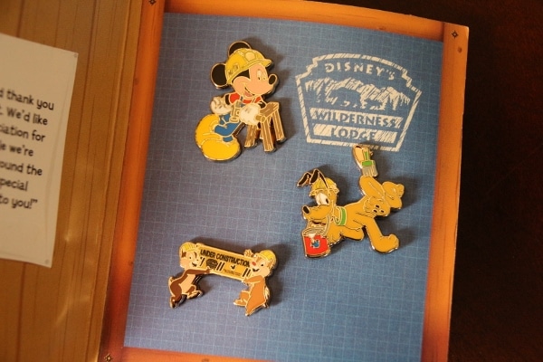three construction-themed Disney pins in a little book