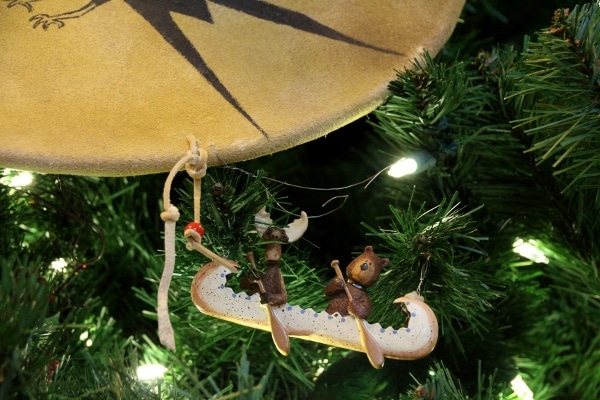 a closeup of a Christmas ornament of a moose and bear in a canoe